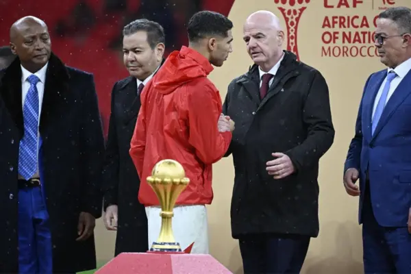 Hakimi walks past AFCON trophy
