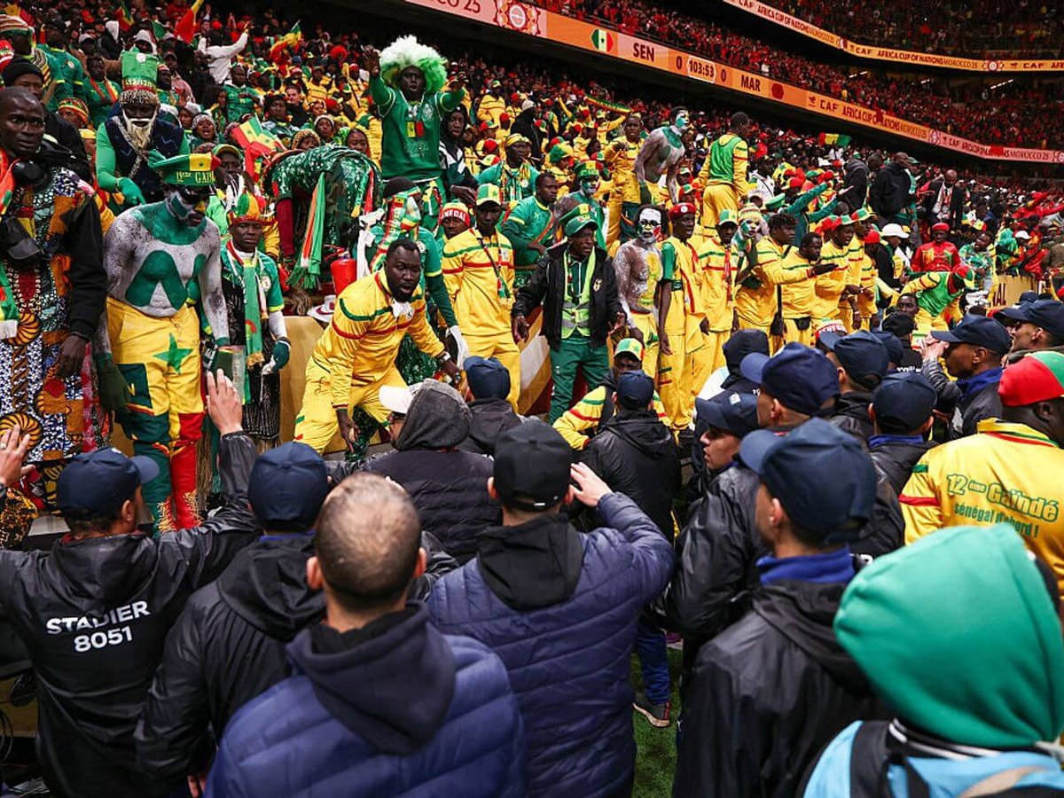 Football fans waving African national flags outside a stadium