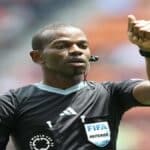 Referee Issa Sy reviewing VAR during a football match