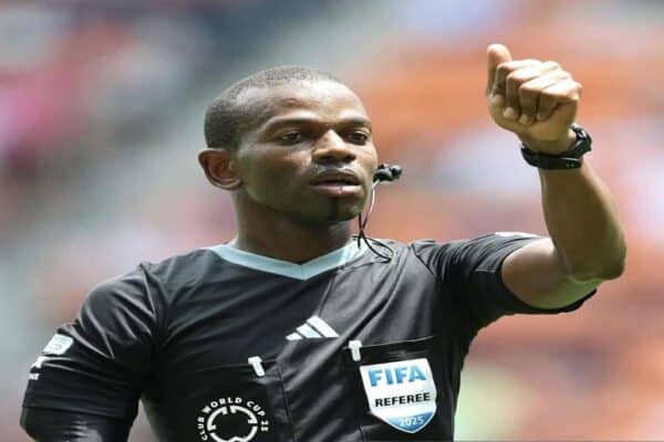 Referee Issa Sy reviewing VAR during a football match