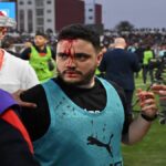Fans on the pitch during a disrupted football match in Safi