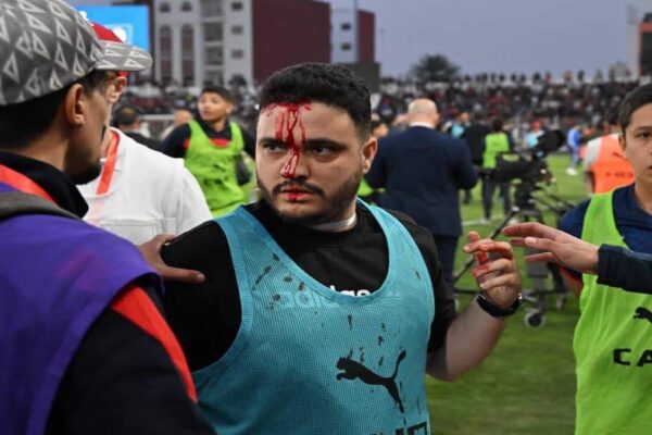 Fans on the pitch during a disrupted football match in Safi