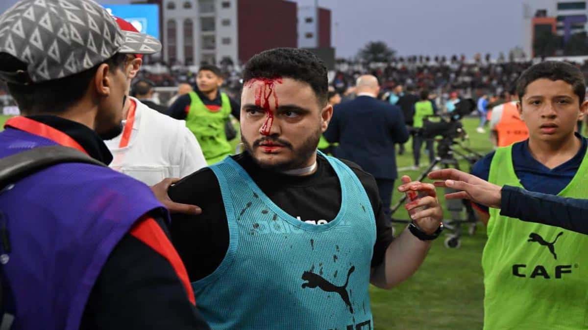 Fans on the pitch during a disrupted football match in Safi