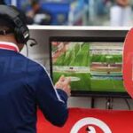 VAR official reviewing footage during a football match
